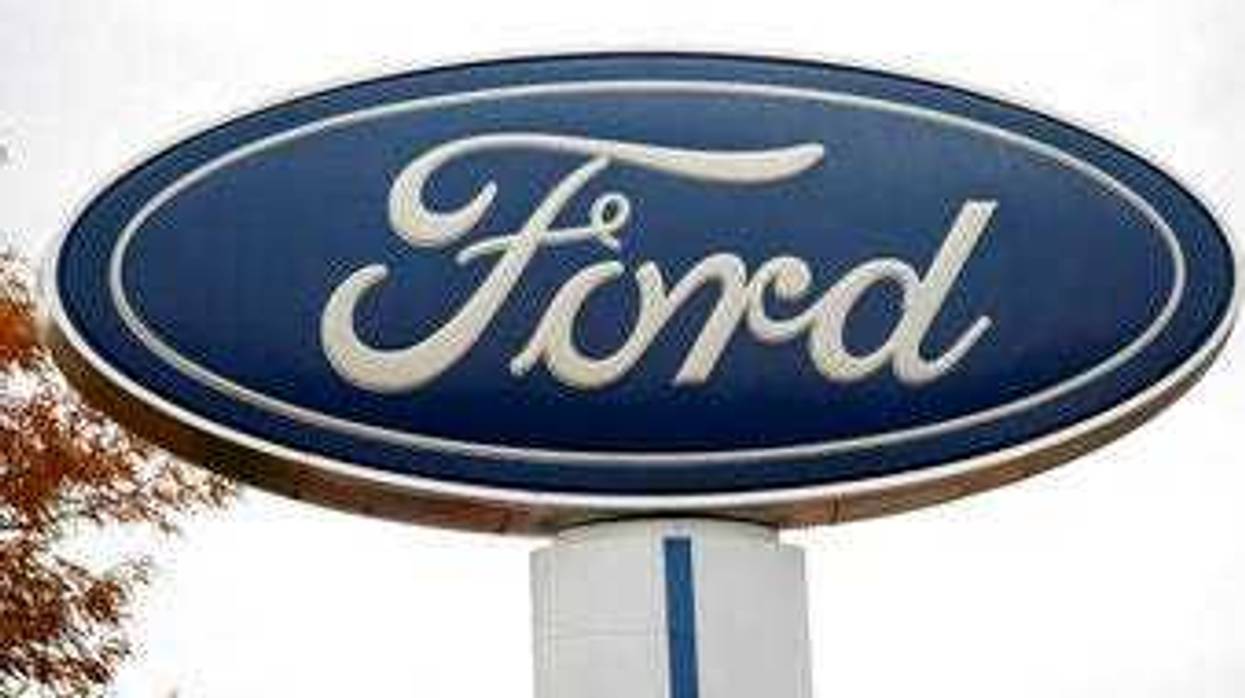 FILE - In this Oct. 20, 2019, file photo, the company logo stands over a long row of unsold vehicles at a Ford dealership in Littleton, Colo. (AP Photo/David Zalubowski, File)