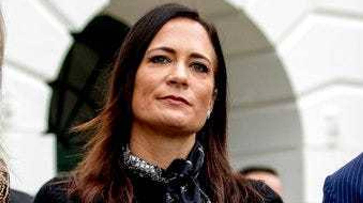 FILE- In this Oct. 3, 2019 file photo, White House press secretary Stephanie Grisham listens as President Donald Trump speaks to the media on the South Lawn of the White House in Washington. (AP Photo/Andrew Harnik)