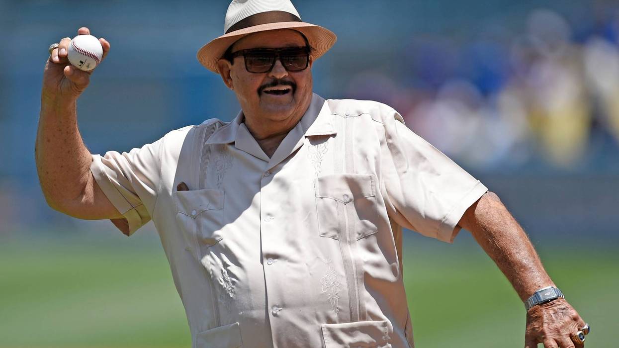 FILE - Los Angeles Dodgers scout Mike Brito throws out the first pitch prior to a baseball game between the Dodgers and the Colorado Rockies in Los Angeles, July 3, 2016. Brito, the top scout in Mexico for the Dodgers for nearly 45 years who discovered such talents as Fernando Valenzuela, current Dodgers pitcher Julio Urías and Yasiel Puig, died Thursday, July 7, 2022. He was 87. The team announced his death to the crowd before hosting the Chicago Cubs and held a moment of silence.