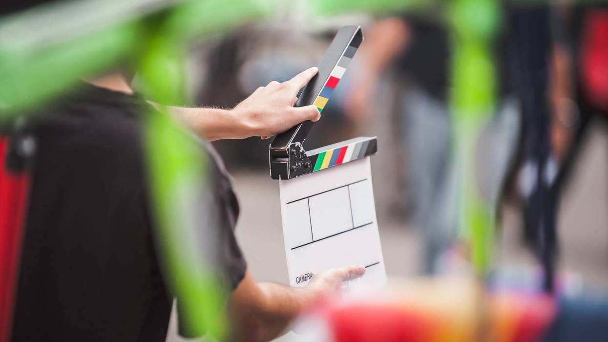 FILE: Man holding a clapperboard in front of the camera.