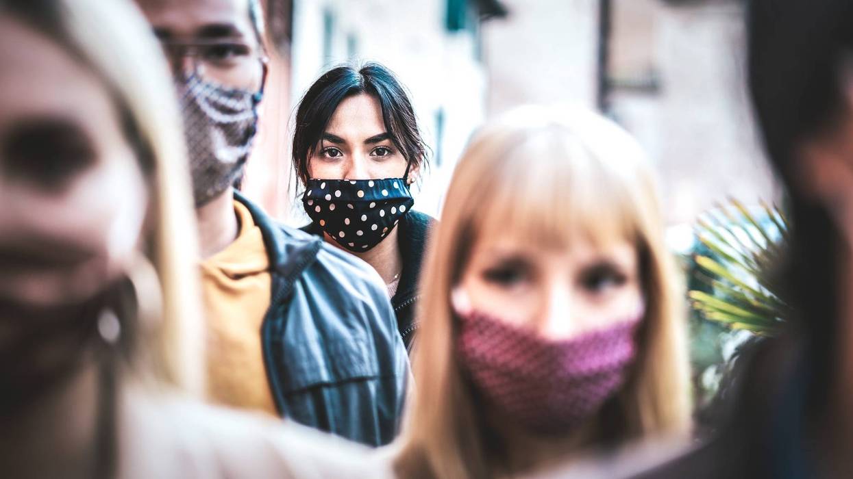 File photo of urban commuters in a crowd of people. All are wearing face masks.