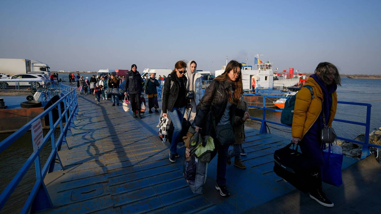 FILE - Refugees fleeing the war from neighbouring Ukraine walk after crossing the border by ferry at the Isaccea-Orlivka border crossing in Romania, Thursday, March 24, 2022.