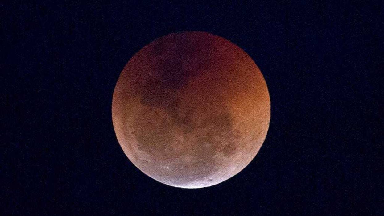 FILE - This Friday, July 27, 2018 file photo shows a blood moon lunar eclipse from the Arpoador beach in Rio de Janeiro, Brazil. Starting Sunday evening, Jan. 20, 2019, all of North and South America will be able to see the only total lunar eclipse of 201