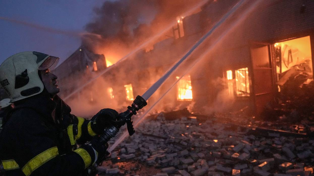 FILE - Ukrainian firefighters extinguish a blaze at a warehouse after a bombing on the outskirts of Kyiv, Ukraine, Thursday, March 17, 2022. Russian forces destroyed a theater in Mariupol where hundreds of people were sheltering Wednesday and rained fire on other cities, Ukrainian authorities said, even as the two sides projected optimism over efforts to negotiate an end to the fighting.