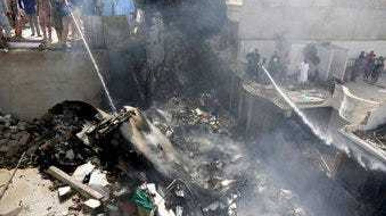 Fire brigade staff try to put out fire caused by plane crash in Karachi, Pakistan, Friday, May 22, 2020. (AP Photo/Fareed Khan)