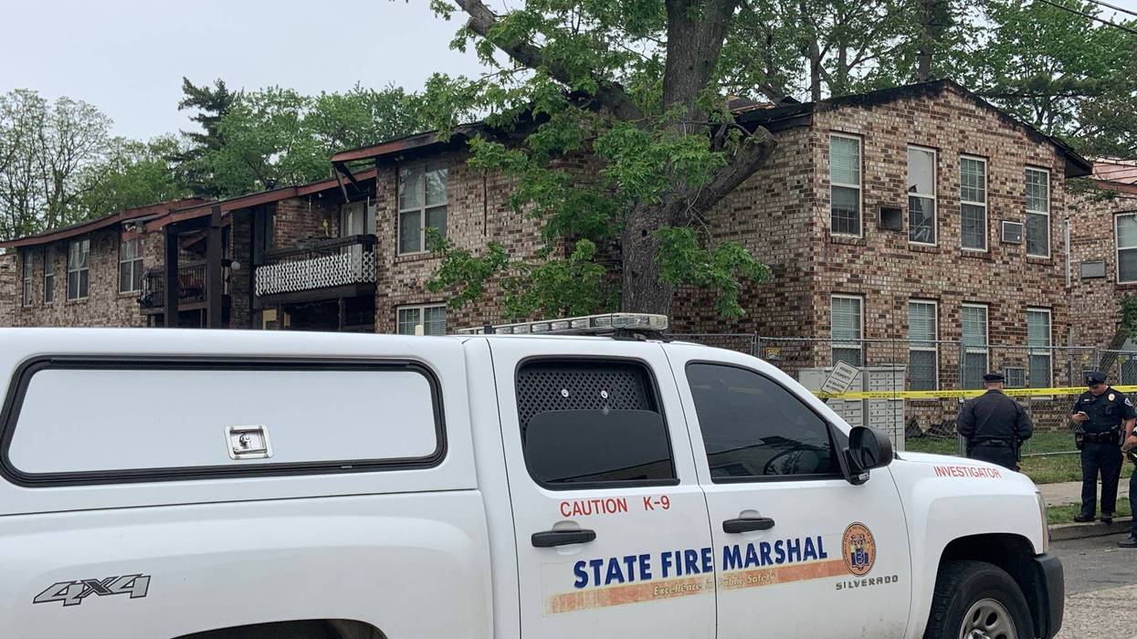 Fire officials outside an apartment complex following a morning fire.
