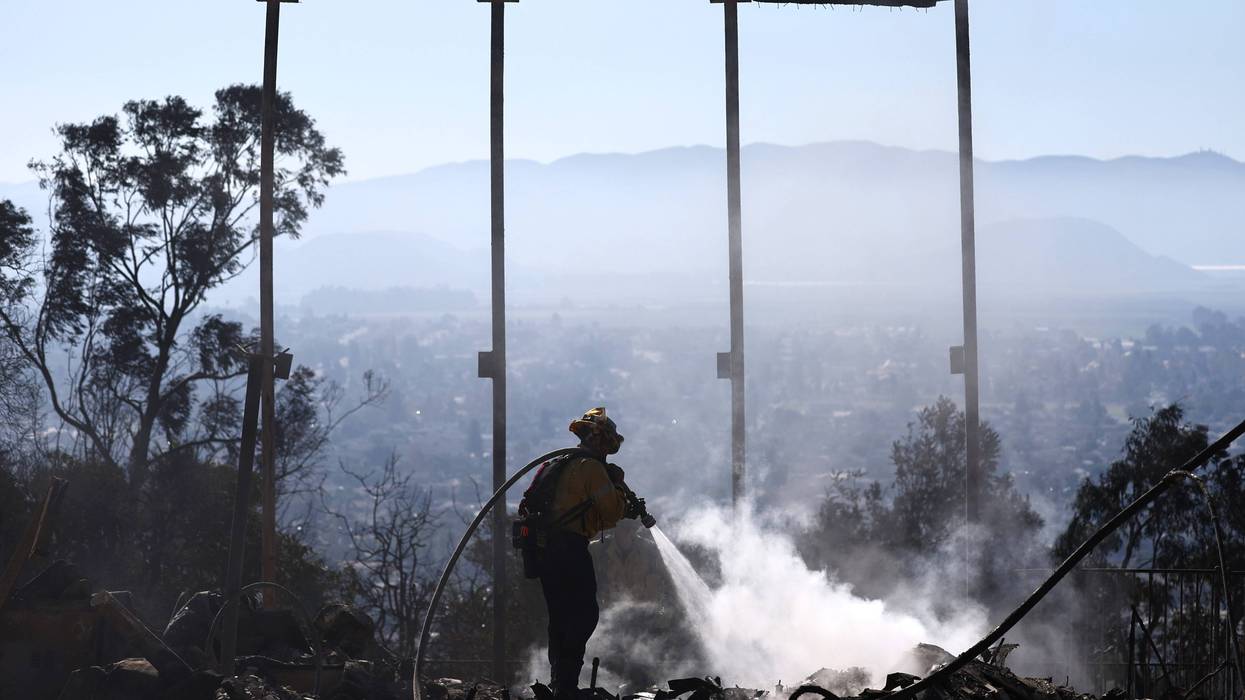 firefighter hosing down fire