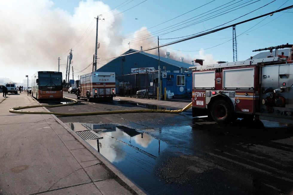 Firefighters and other emergency personnel work to control a large fire in the Brooklyn neighborhood of Red Hook on December 13, 2022