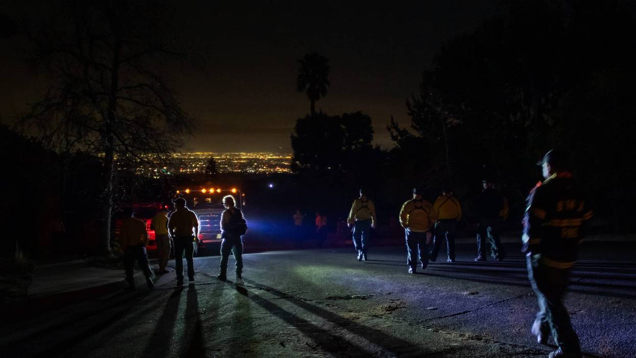 Firefighters from Seattle, WA walk to their fire trucks after a briefing meeting outside Sullivan Canyon Park right before midnight to start fighting the Palisades Fire on Jan. 10, 2025, in Los Angeles, California.