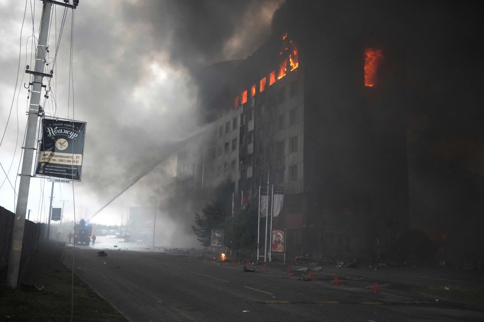 Firefighters hose down a burning building after bombing in Kyiv, Ukraine, Thursday, March 3, 2022