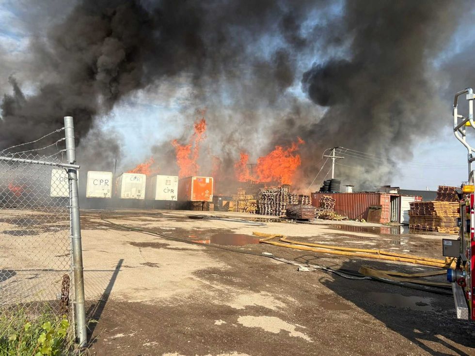 Firefighters in Gary spent more than 18 hours Sunday battling a massive blaze at a pallet company that later reignited, damaging an adjacent property, officials said.