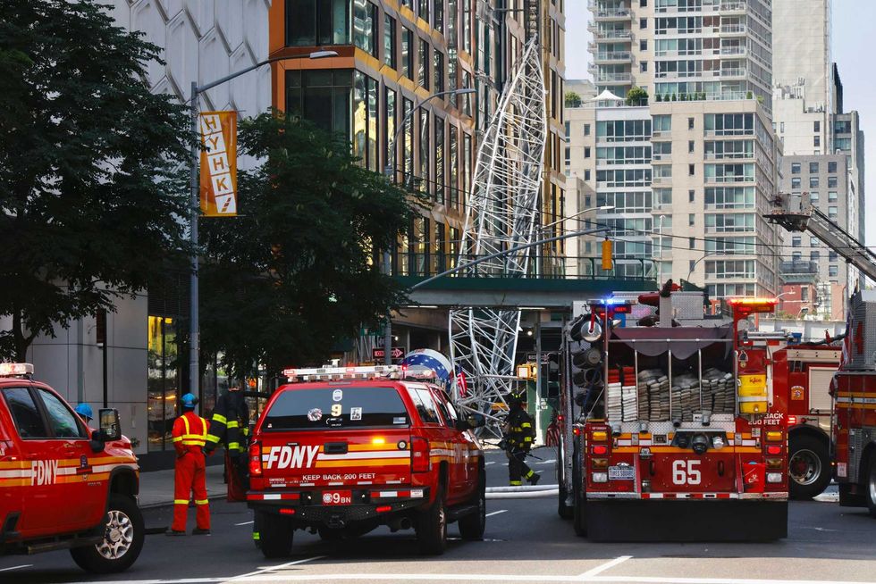 Firefighters inspect a construction crane that caught fire and collapsed in Hell
