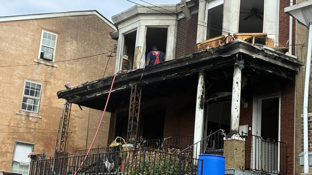 Firefighters inspect the aftermath of a fire at a Manayunk rowhome on the 4400 block of Fleming Street that killed a woman.