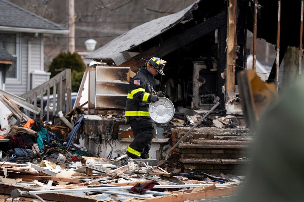 Firefighters sort through the rubble after an explosion during a house fire in Pompton Lakes.