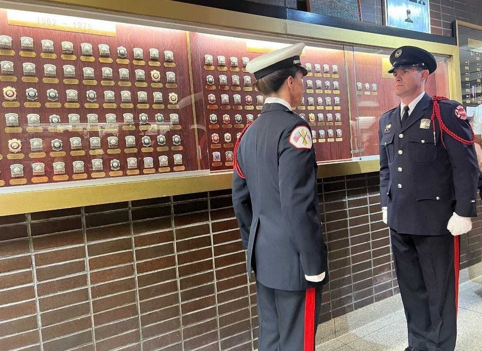 Firefighters stand at attention during the badge ceremony