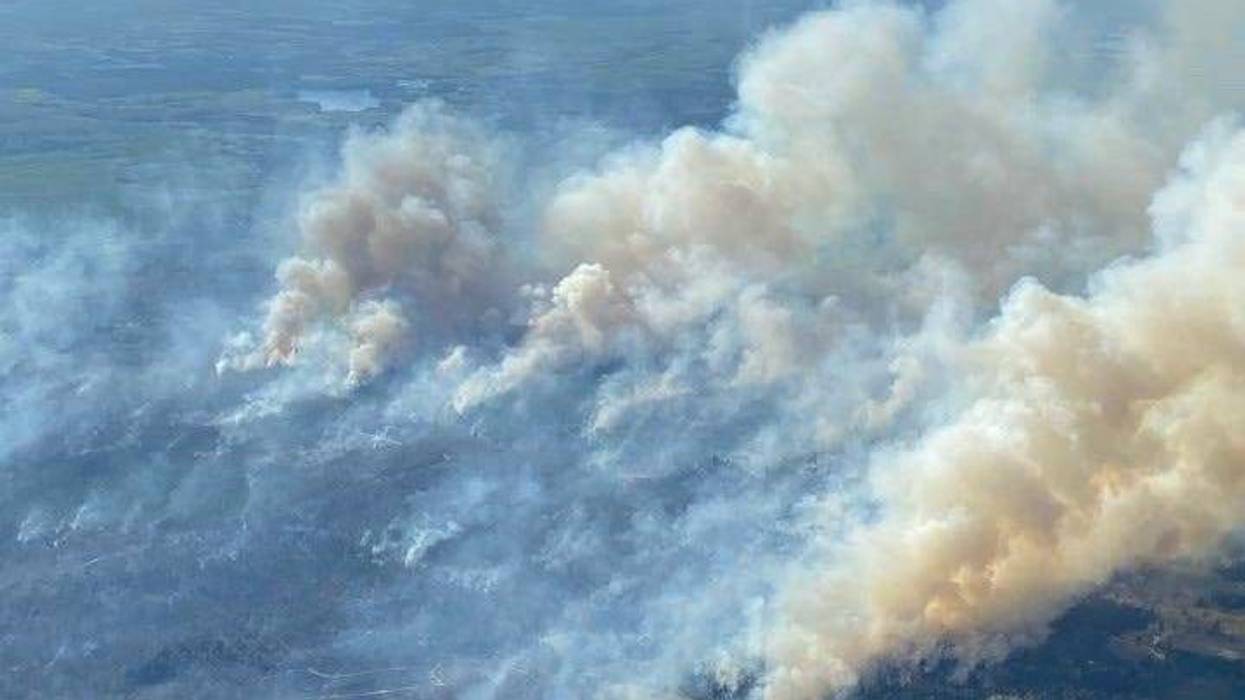 Firefighters with the Michigan Department of Natural Resources and local fire crews are battling back a raging wildfire burning Montmorency and Cheboygan counties, officials said Saturday morning.