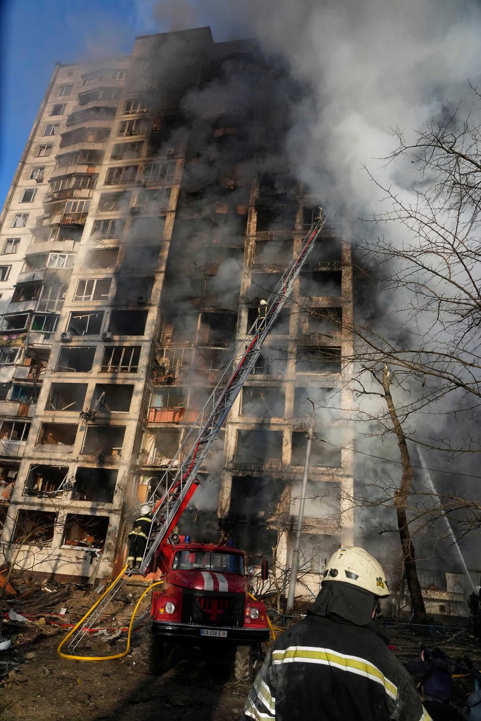 Firefighters work in an apartment building damaged by shelling in Kyiv, Ukraine, Tuesday, March 15, 2022