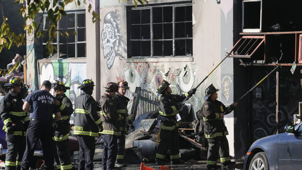 Firefighters work to clear debris at the site of the Ghost Ship warehouse in Oakland where 36 people died in a fire in 2016.