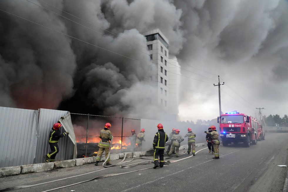 Firefighters work to extinguish a fire at a damaged logistic center after shelling in Kyiv, Ukraine, Thursday, March 3, 2022