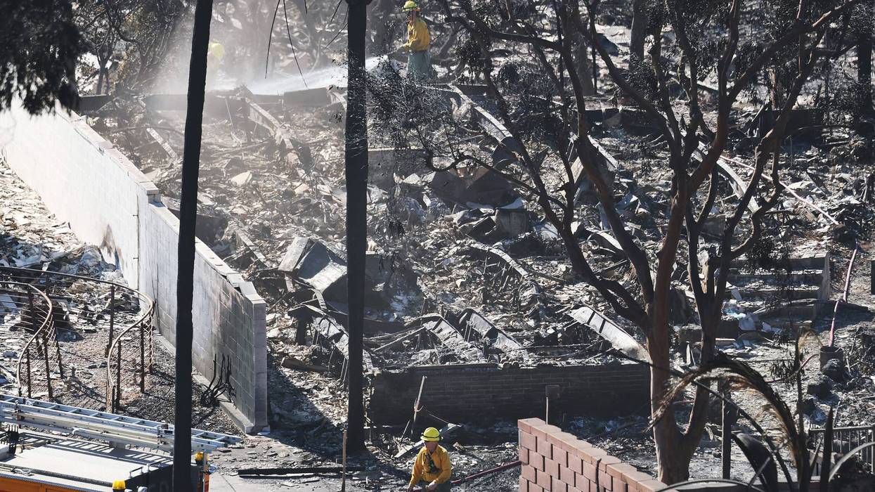 Firefighters work to extinguish hotspots at homes destroyed in the Palisades Fire on January 13, 2025 in Pacific Palisades, California.