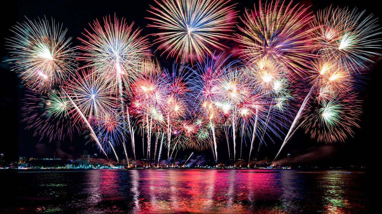 Fireworks light up the sky over a river