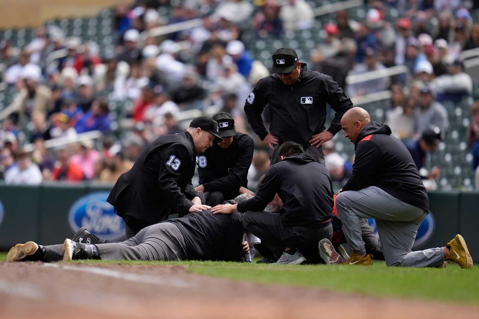 First base umpire Hunter Wendelstedt is attended to after being hit by a foul ball during the seventh inning of a baseball game between the Minnesota Twins and New York Mets, Wednesday, April 16, 2025, in Minneapolis.