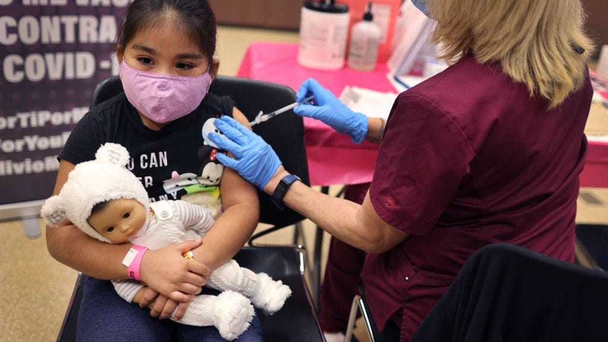 First grade student Rihanna Chihuaque, receives a COVID-19 vaccine at Arturo Velasquez Institute on November 12, 2021 in Chicago, Illinois.(Photo by Scott Olson/Getty Images)