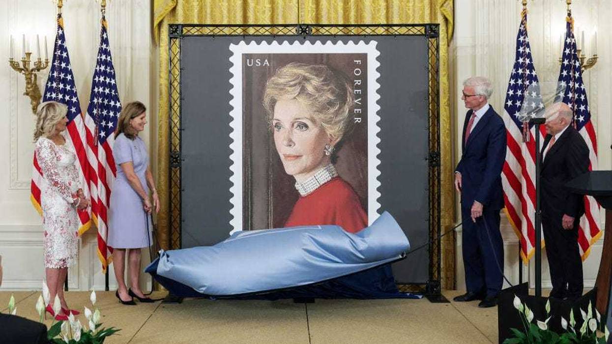 First Lady Jill Biden, Anne Peterson, Nancy Reagan’s niece, Fred Ryan, Chairman of the Board of Trustees of The Ronald Reagan Presidential Foundation and Institute and Louis DeJoy, U.S. Postal Service Postmaster General, unveil the Nancy Regan stamp, in the East Room at the White House on June 06, 2022 in Washington, DC. The U.S. Postal Service unveiled the stamp honoring the legacy of First Lady Nancy Reagan and her role in helping to shape President Ronald Regan's Administration. (Photo by Kevin Dietsch/Getty Images)