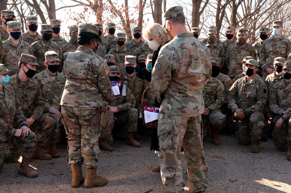 First lady Jill Biden talks with members of the National Guard, after surprising them with chocolate chip cookies and posing for photos outside the Capitol on January 22, 2021, in Washington, DC.