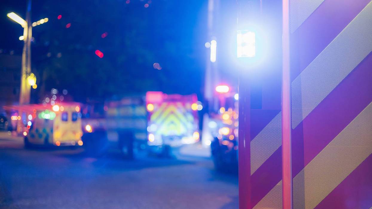 Flashing Fire Trucks and Ambulance on City Street at Night