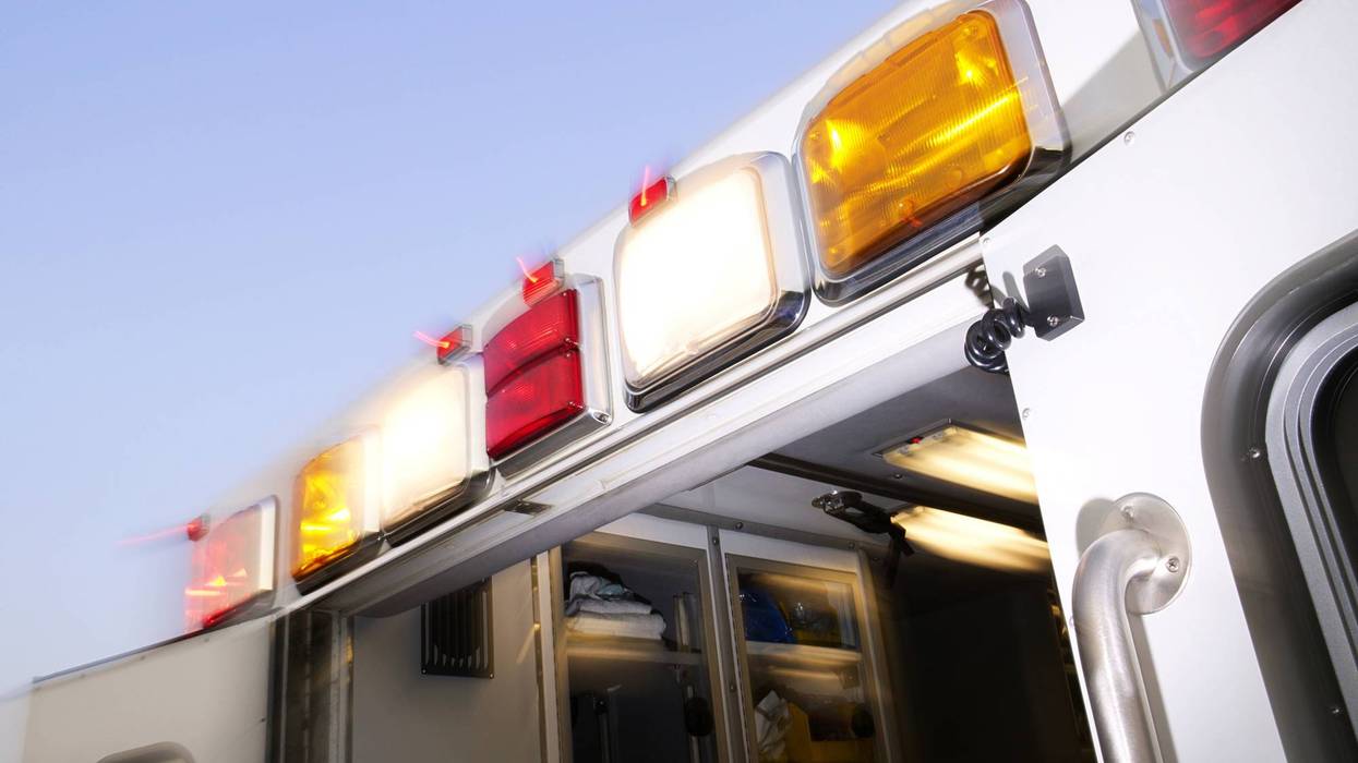 Flashing red, white, and amber emergency lights on an ambulance with its rear door open.