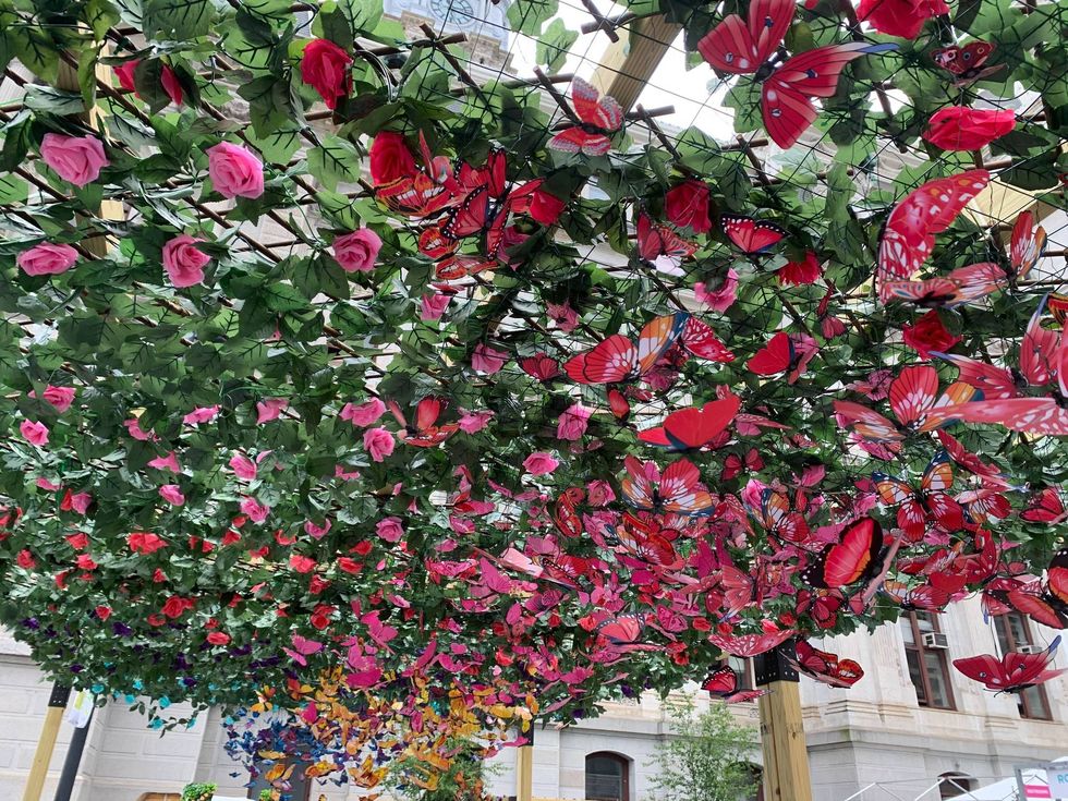 Floral pergolas with waves of silk butterflies decorate Dilworth Park this weekend, in a pop-up installation called "The Garden."