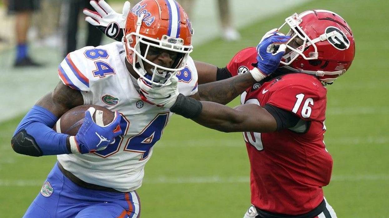 Florida tight end Kyle Pitts (84) tires to get past Georgia defensive back Lewis Cine (16) after a reception during the first half of an NCAA college football game, Saturday, Nov. 7, 2020, in Jacksonville, Fla.
