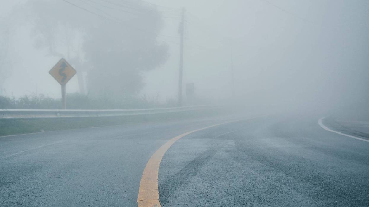 foggy rural asphalt highway perspective with white line, misty road, Road with traffic and heavy fog, bad weather driving