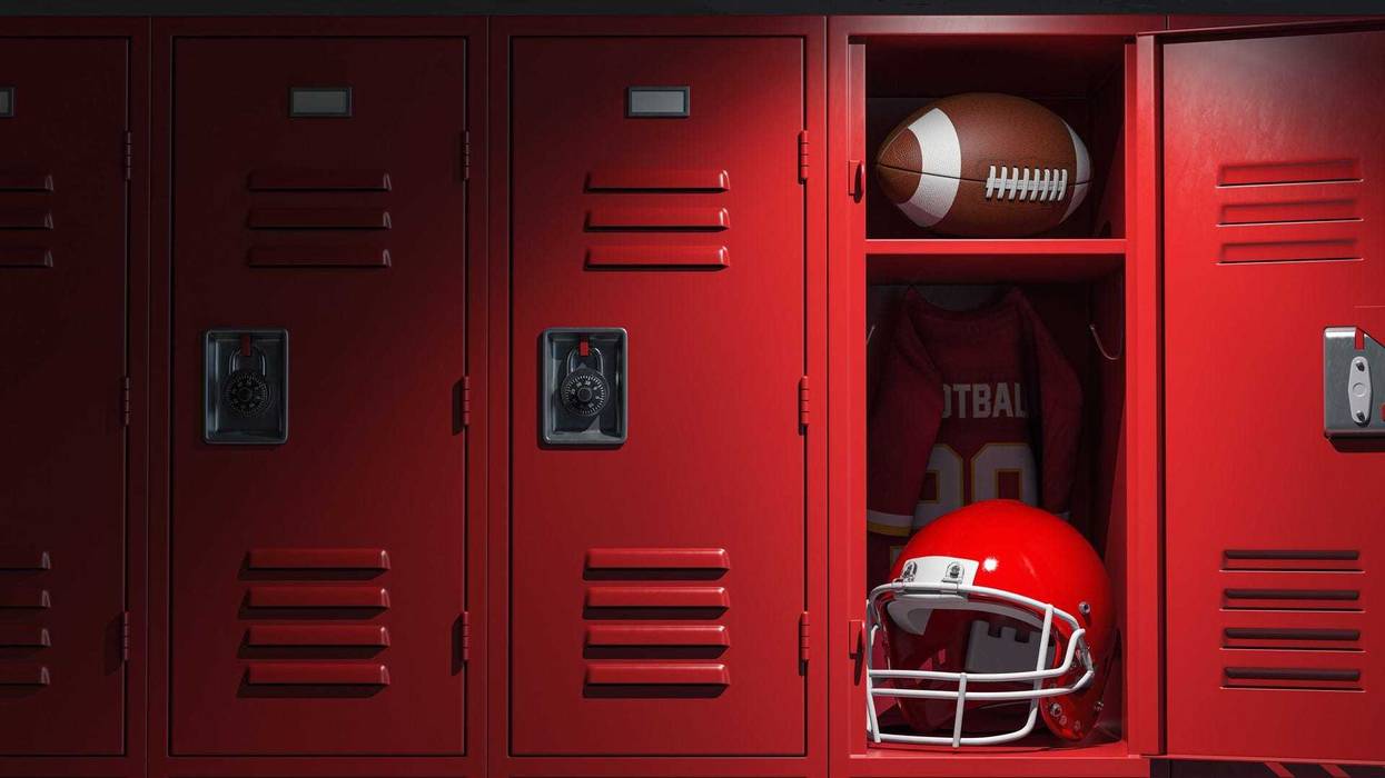 Football locker room with equipment, ball and helmet