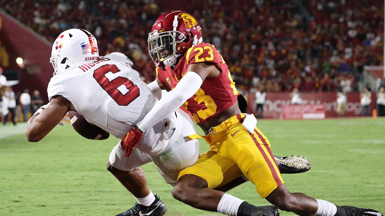 football player tackles another football player in the endzone