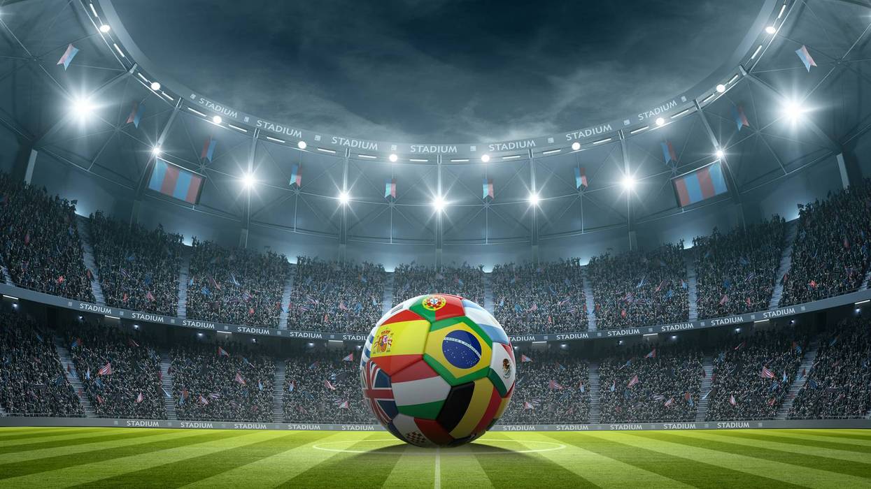 Football with international flags in the stadium at night.