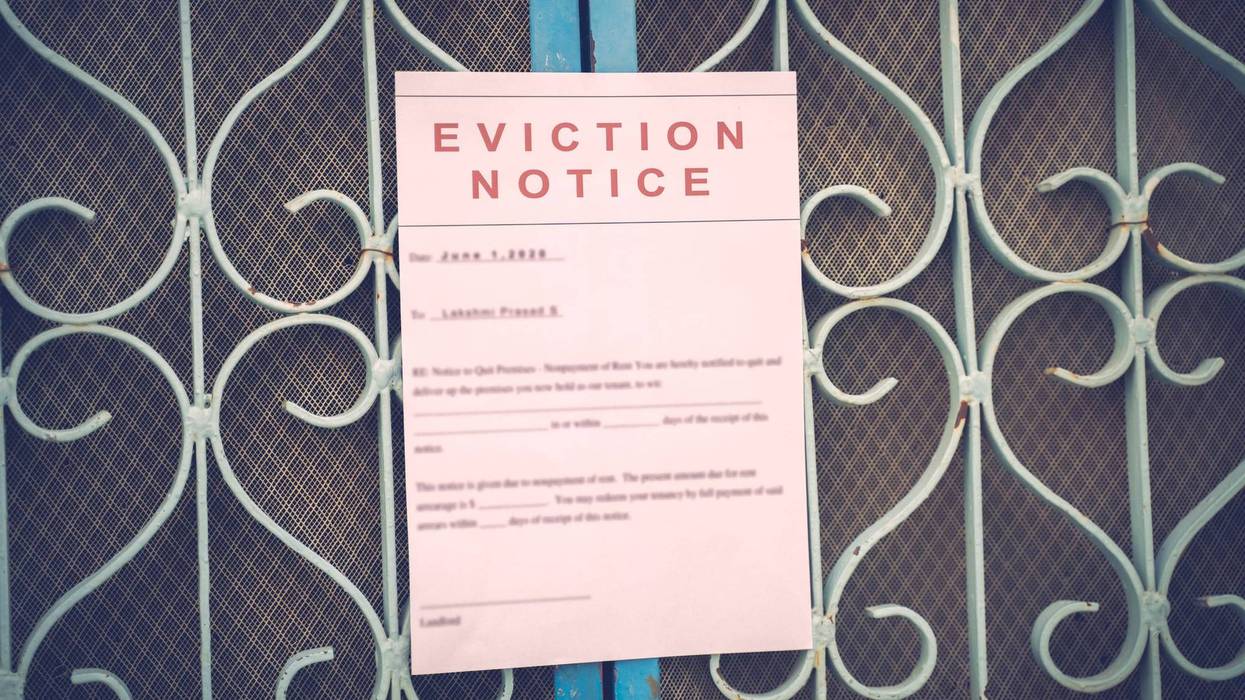 Foreclosed or eviciton notice on a main door with blurred details of a house with vintage filter.