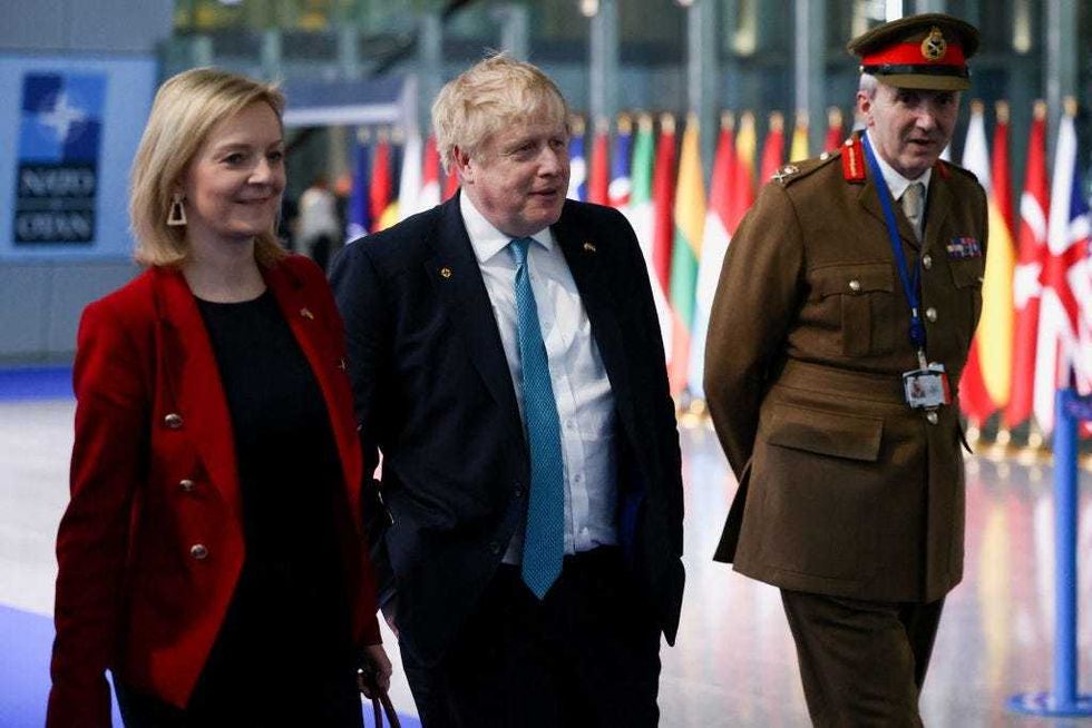 Former British Prime Minister Boris Johnson and former Foreign Secretary Liz Truss, who succeeded him as prime minister, as well as military representative to NATO Ben Bathurst leave NATO Headquarters following a NATO summit on Russia