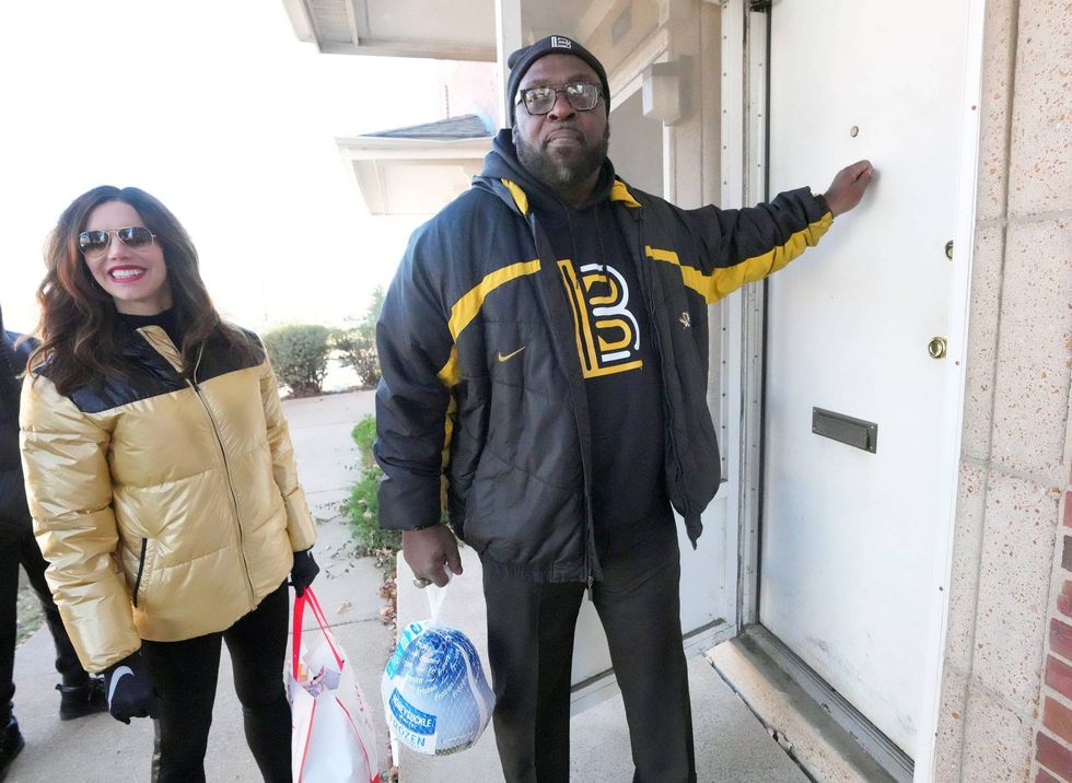 Former Detroit Lions Demetrious Johnson along with University of Missouri Athletic Director Desiree Reed-Francois, knock on a door to deliver a Thanksgiving Day turkey and fixings at an apartment complex in St. Louis on Saturday, November 19, 2022. Over 3,000 turkeys were delivered to those of underprivileged households for Thanksgiving Day by the Demetrious Johnson Foundation.