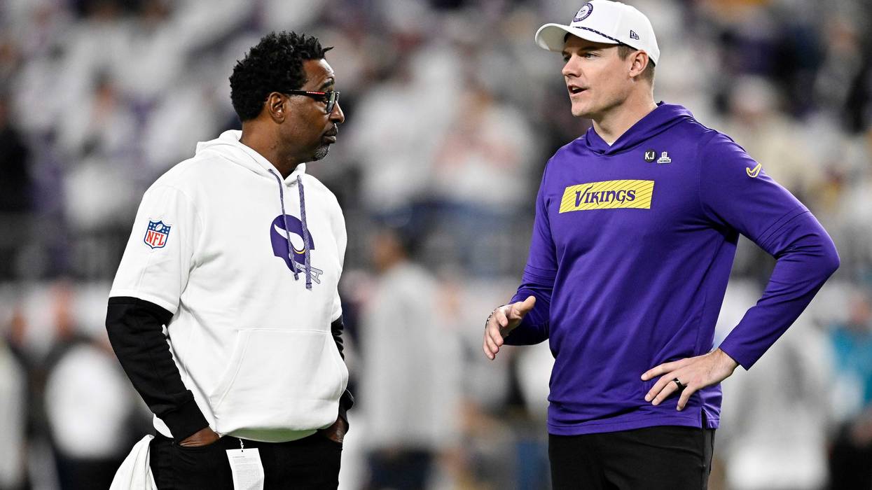 Former Minnesota Vikings player Cris Carter speaks with ead coach Kevin O'Connell of the Minnesota Vikings prior to a game against the Chicago Bears at U.S. Bank Stadium on December 16, 2024 in Minneapolis, Minnesota.