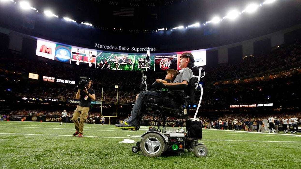 former New Orleans Saints player Steve Gleason rides onto the field with with his son Rivers before an NFL football game against the Atlanta Falcons in New Orleans