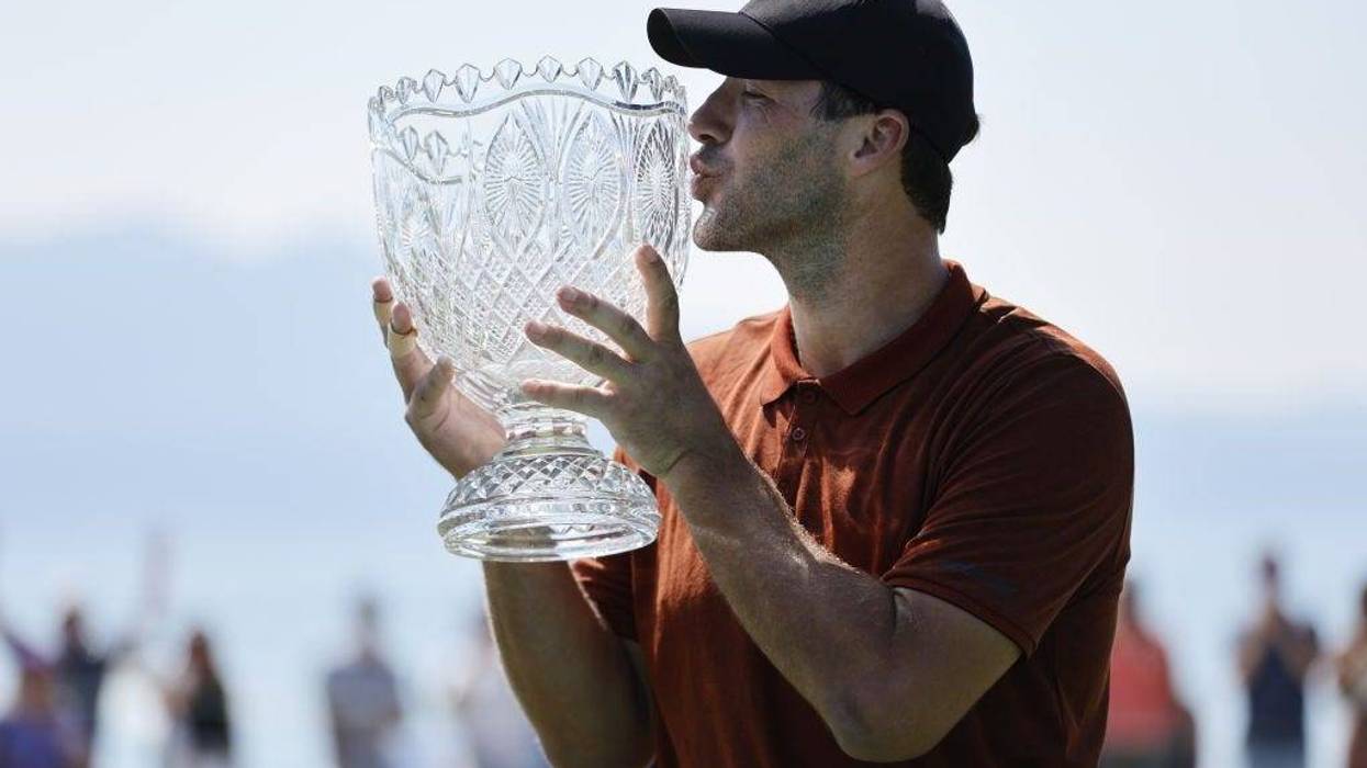 Former NFL quarterback Tony Romo kisses the trophy after winning the American Century Championship at Edgewood Tahoe Golf Course on July 10, 2022 in Stateline, Nevada.