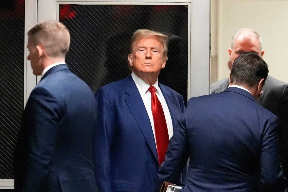 Former President Donald Trump, center, leaves a pre-trial hearing during a recess with his defense team at Manhattan criminal, Monday, March 25, 2024, in New York
