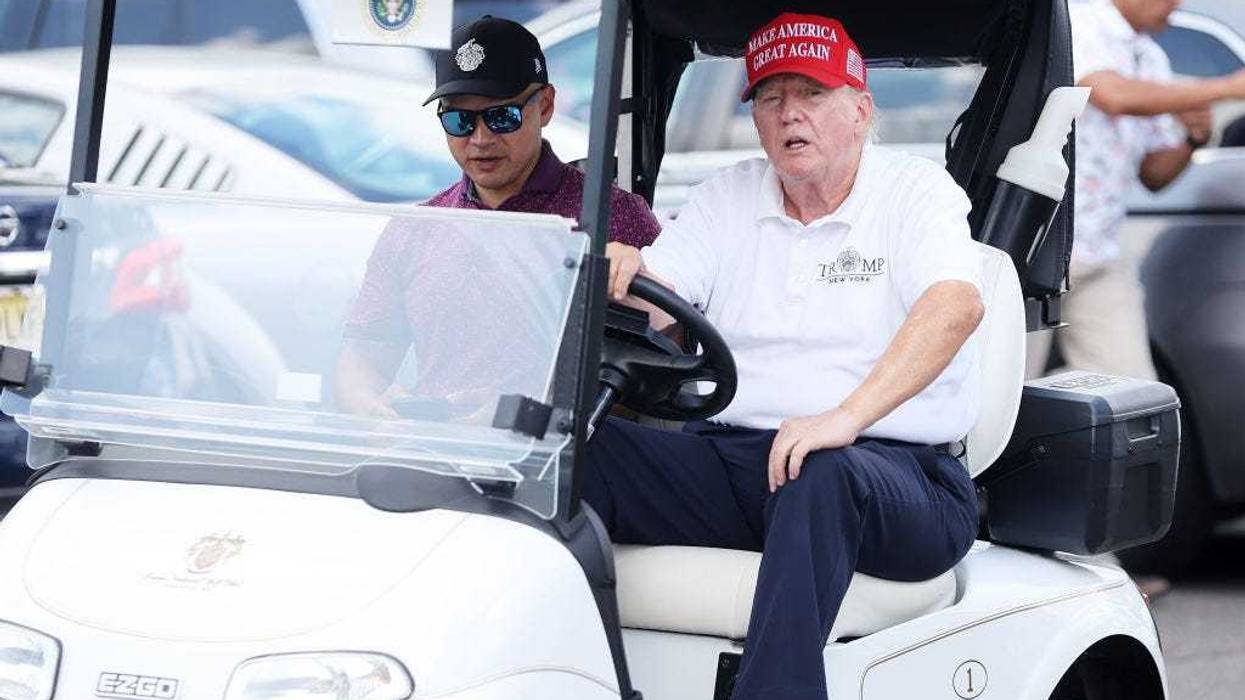 Former President Donald Trump drives a golf cart accompanied by aide Walt Nauta prior to the start of day three of the LIV Golf Invitational - Bedminster at Trump National Golf Club on August 13, 2023 in Bedminster, New Jersey. (Photo by Mike Stobe/Getty Images)