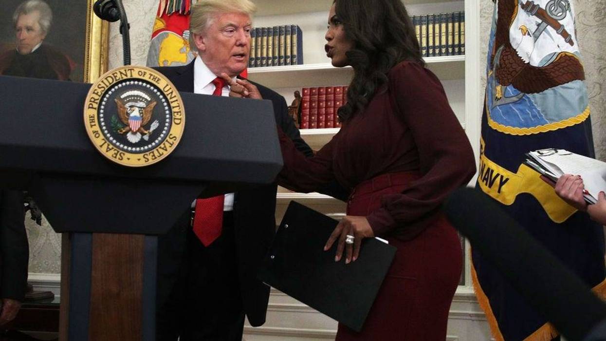 Former President Donald Trump listens to Director of Communications for the White House Public Liaison Office Omarosa Manigault during an event in the Oval Office of the White House October 24, 2017.