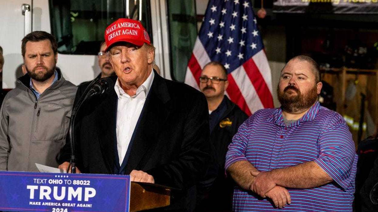 Former President Donald Trump stands next to a pallet of water before delivering remarks at the East Palestine Fire Department station on February 22, 2023 in East Palestine, Ohio.
