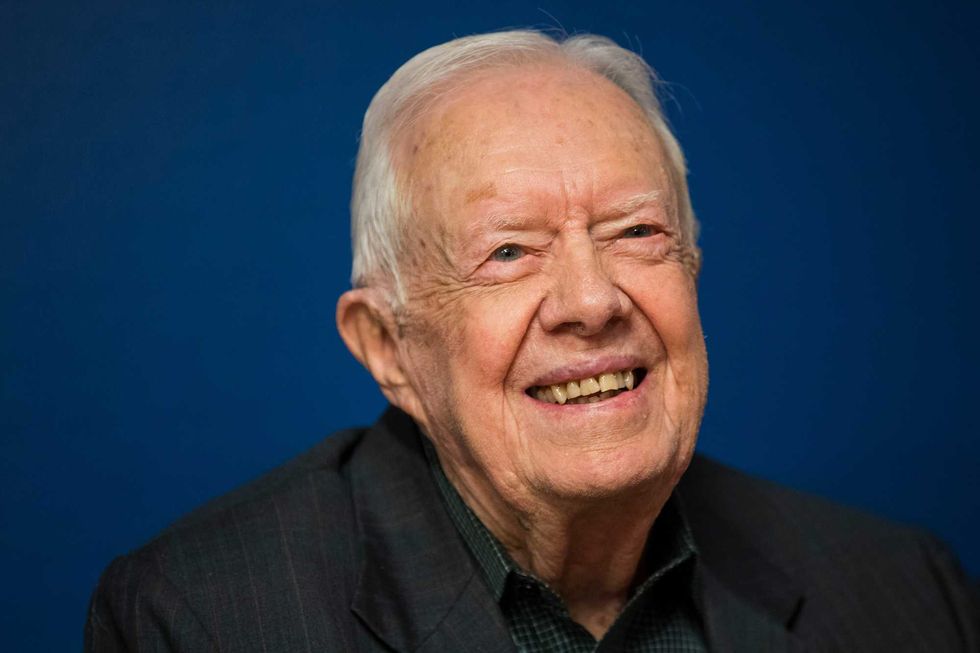 Former President Jimmy Carter smiles during a book signing event for his book