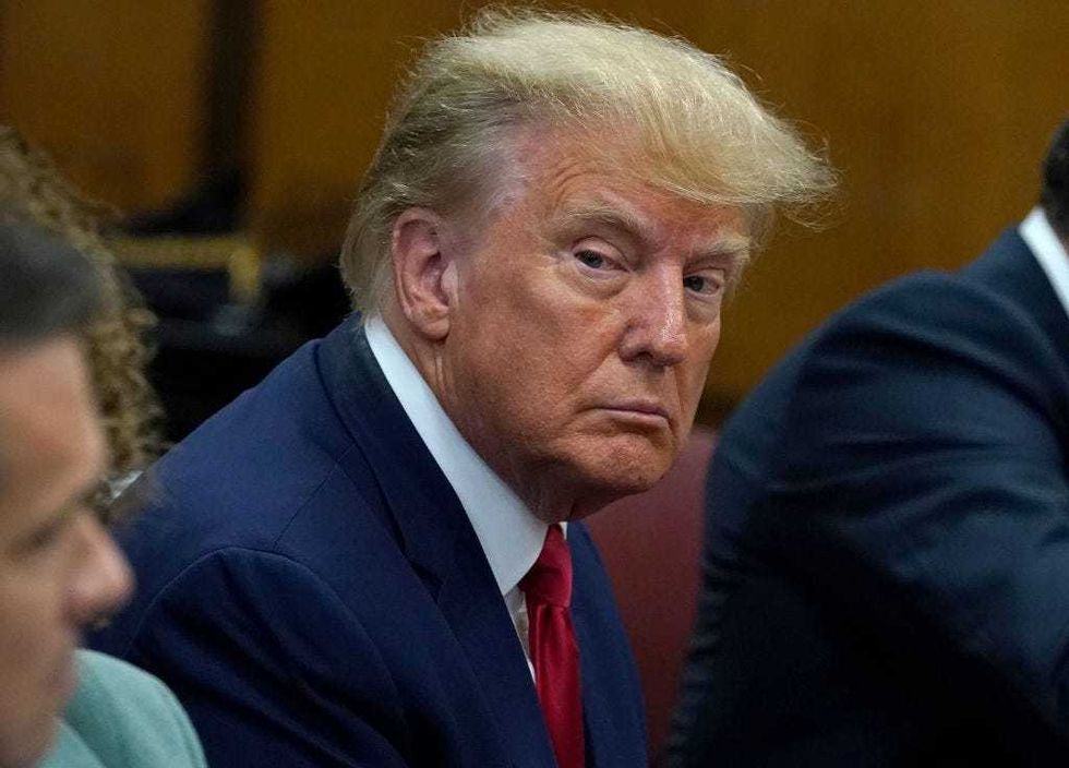 Former U.S. President Donald Trump sits with his attorneys inside the courtroom during his arraignment at the Manhattan Criminal Court April 4, 2023 in New York City.