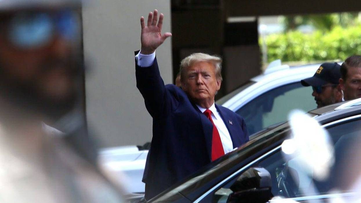 Former U.S. President Donald Trump waves as he makes a visit to the Cuban restaurant Versailles after he appeared for his arraignment on June 13, 2023 in Miami, Florida.